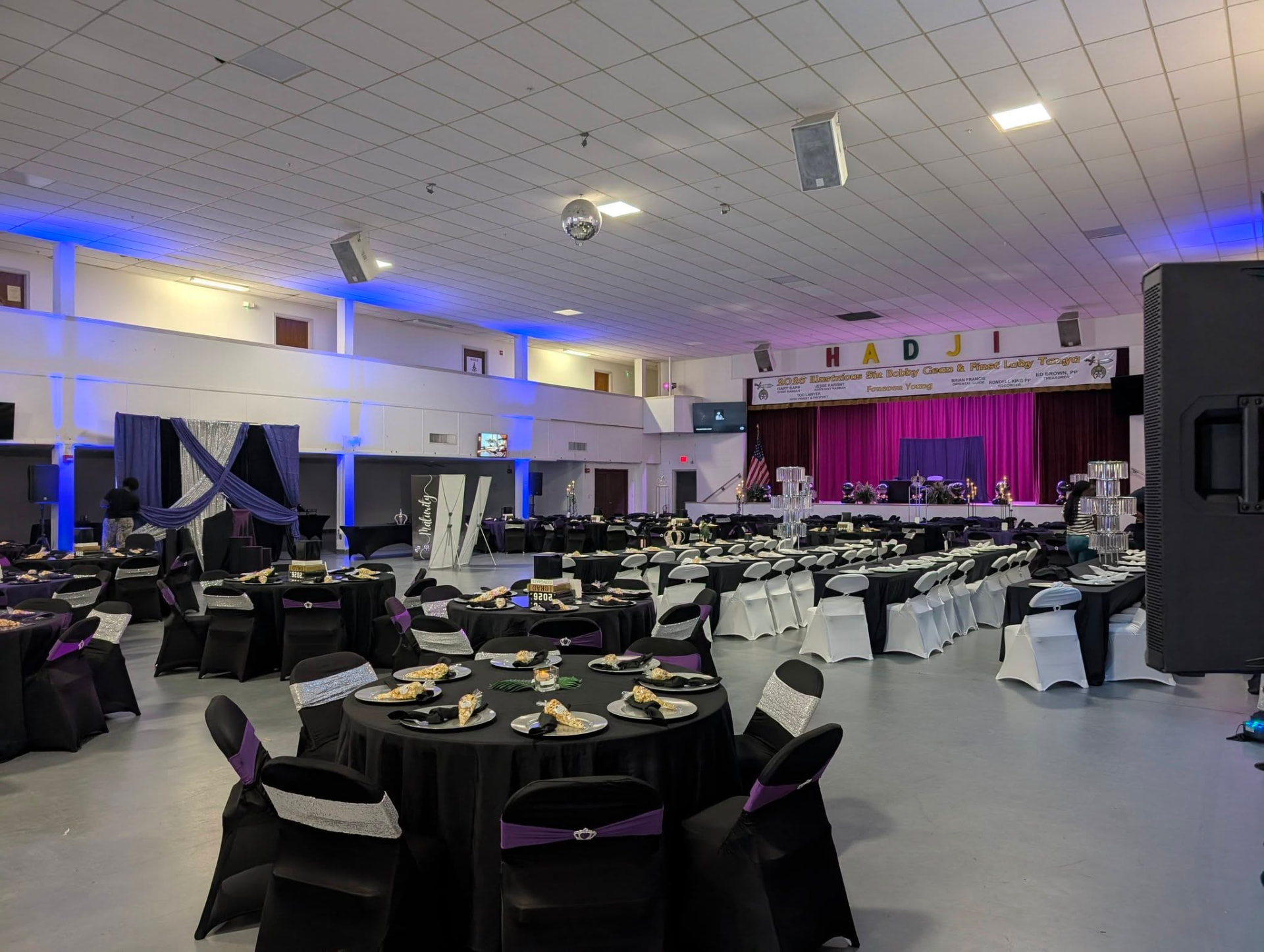 Banquet hall set for a formal organizational gala with full sound and uplighting