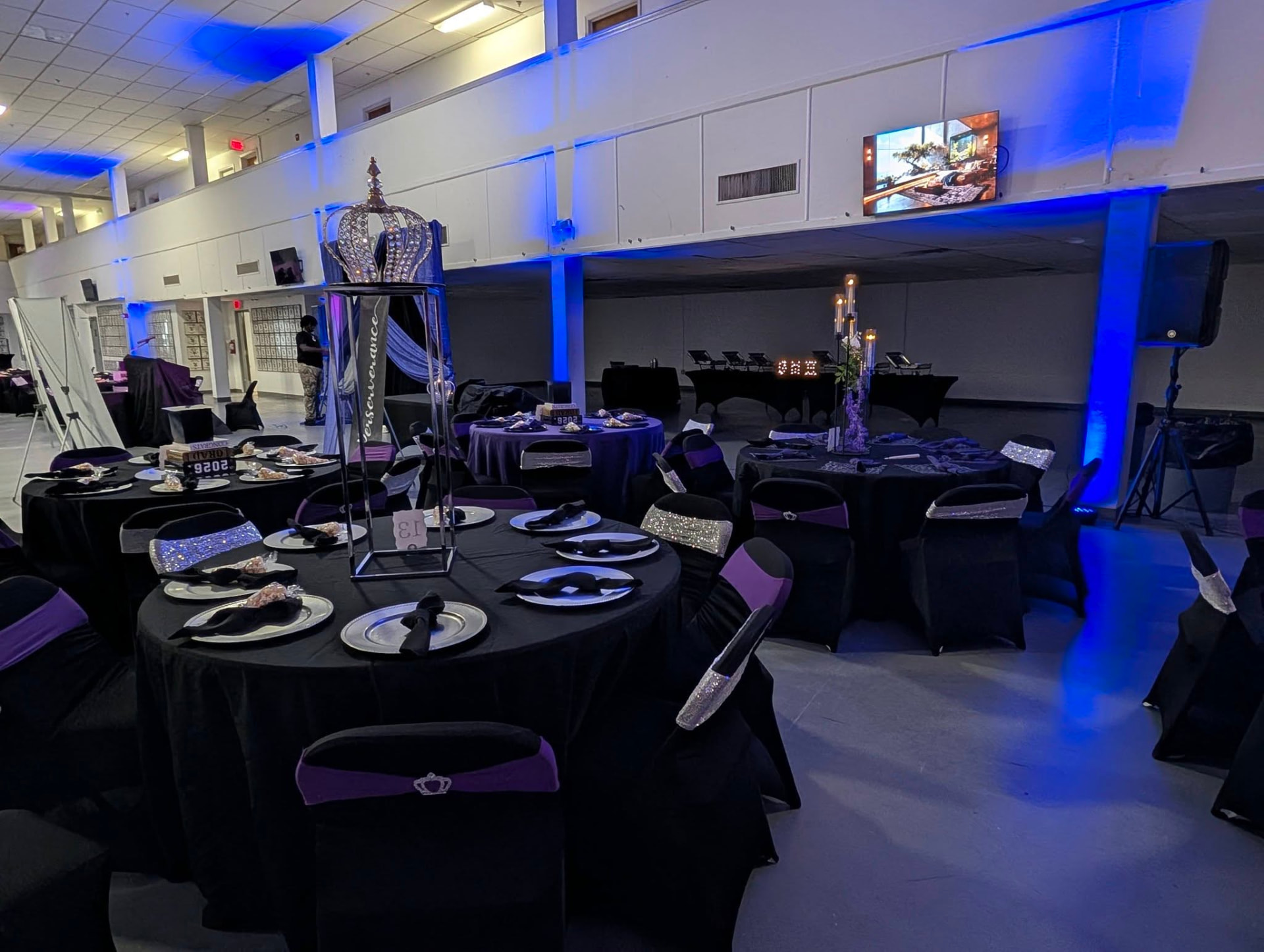 Black and purple banquet tables framed by blue architectural uplighting